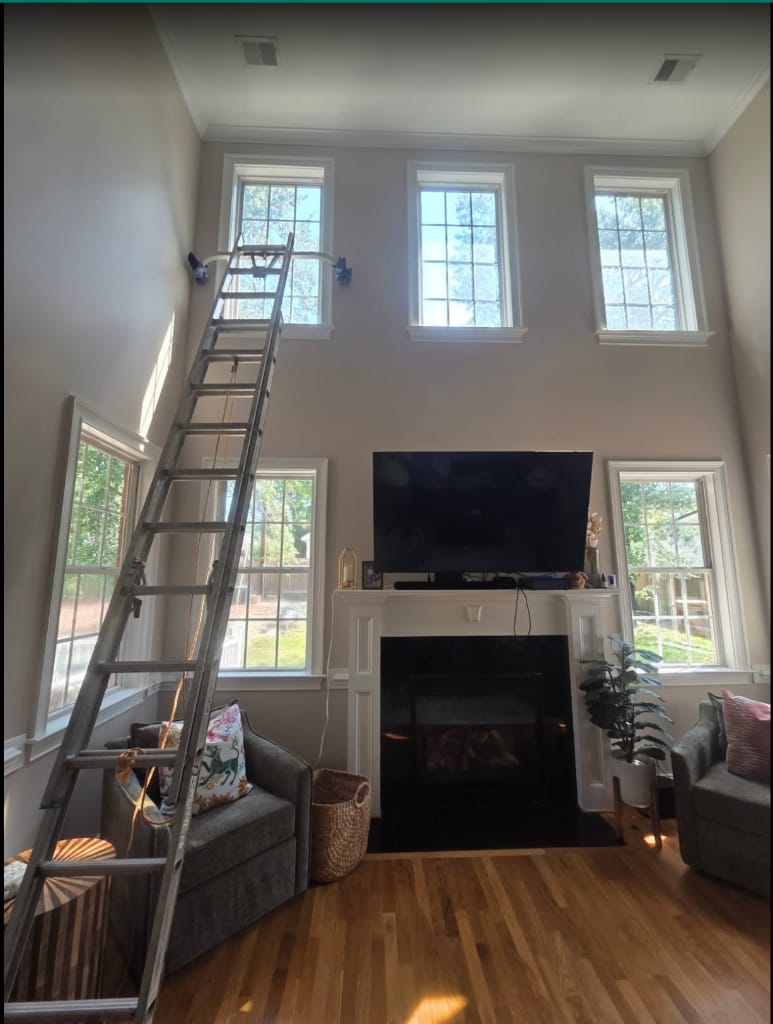 Two-story living room windows before and after interior ladder window cleaning, before cleaning